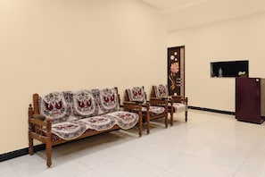 A room with a sofa set, chairs, a cabinet, and a television. - Hotel O New Royal Lodging And Boarding (Nagpur)