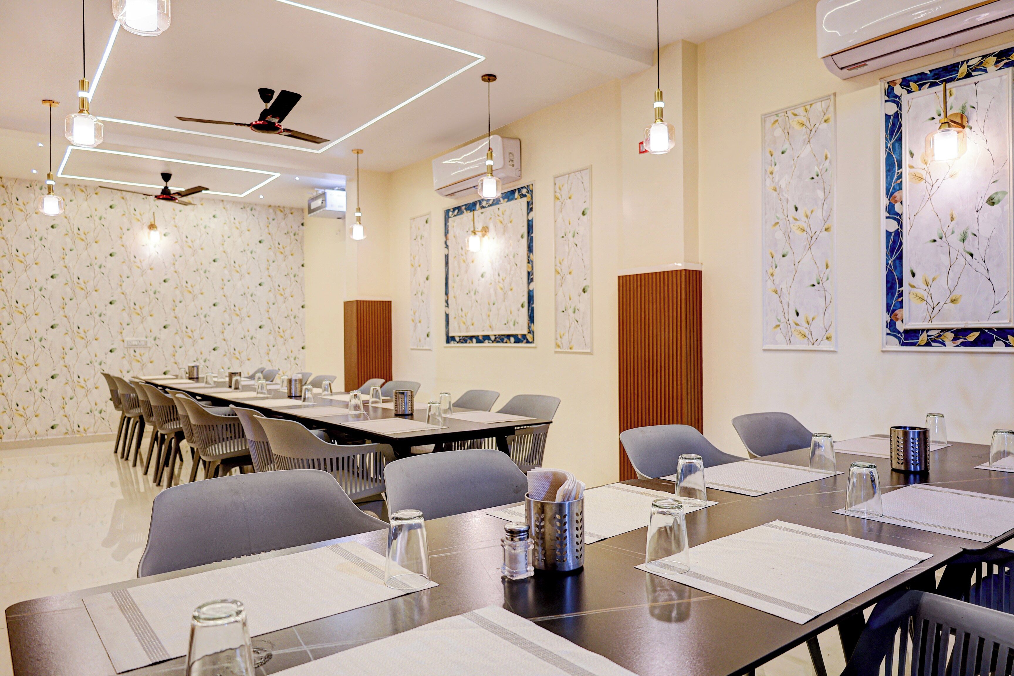 Une salle de conférence avec une longue table, des chaises et un ventilateur de plafond.