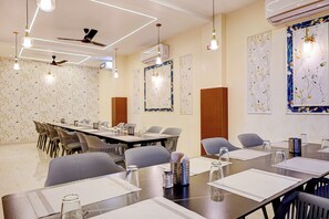 Una sala de conferències amb una taula llarga, cadires i un ventilador al sostre.