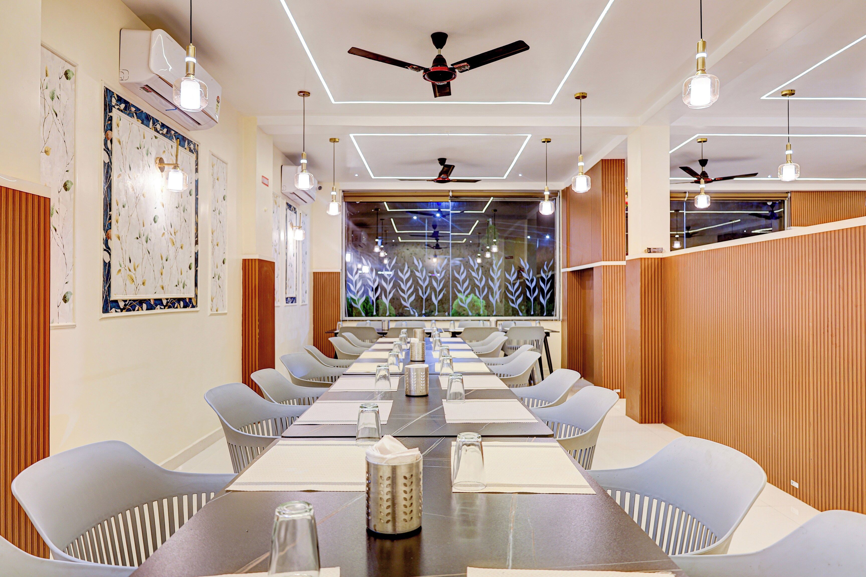 A conference room with a long table, chairs, ceiling fans, and decorative lighting.