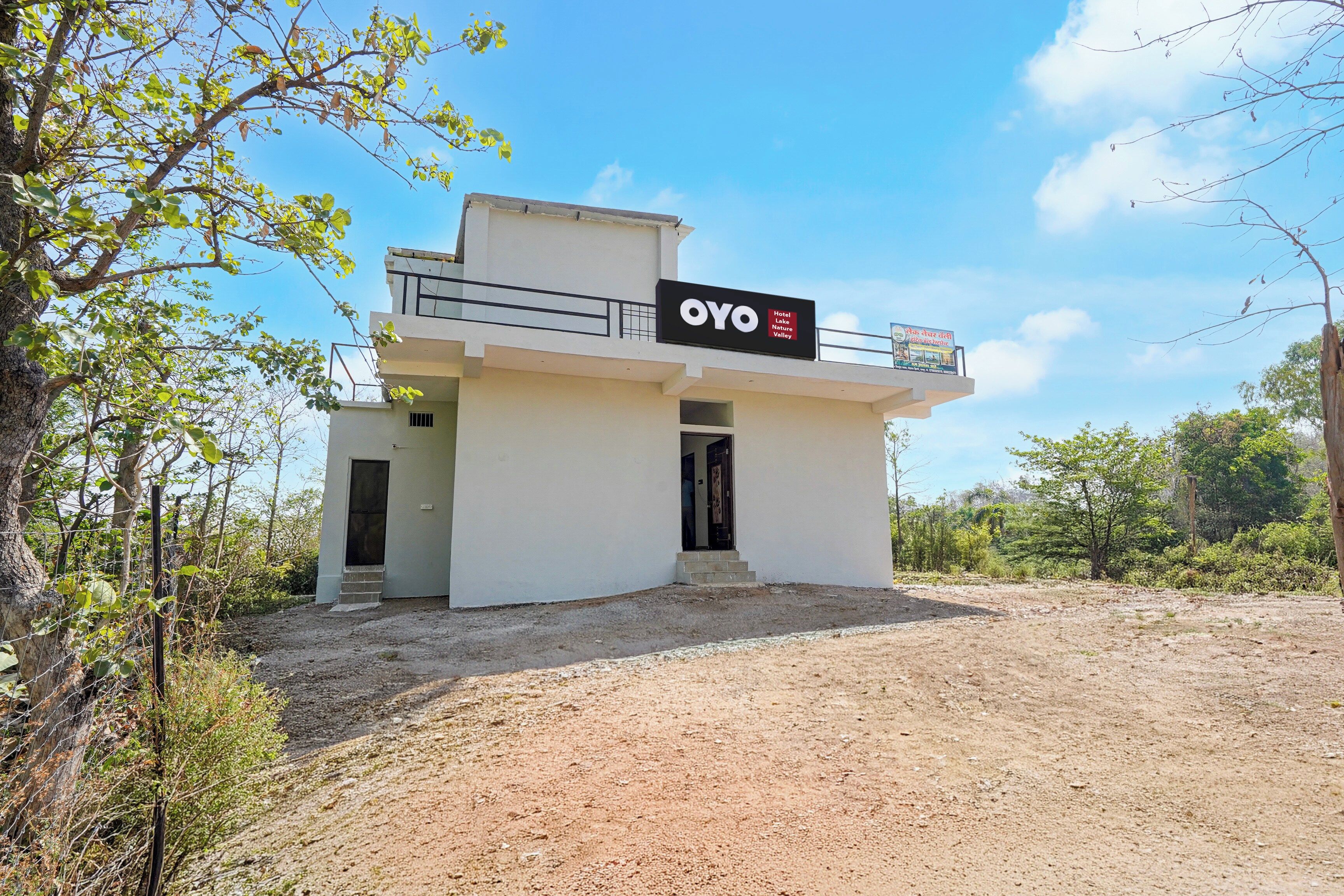 Un edificio de dos pisos con un letrero que dice 'OYO Hotel Lake Nature Valley'.
