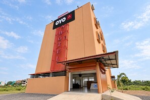 Un hotel con un letrero llamativo, un acceso cubierto y un diseño arquitectónico moderno.