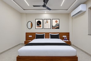 A hotel room with a bed, a ceiling fan, an air conditioning unit, and three framed artworks on the wall. - Hotel O SN HOTEL (Nagpur)