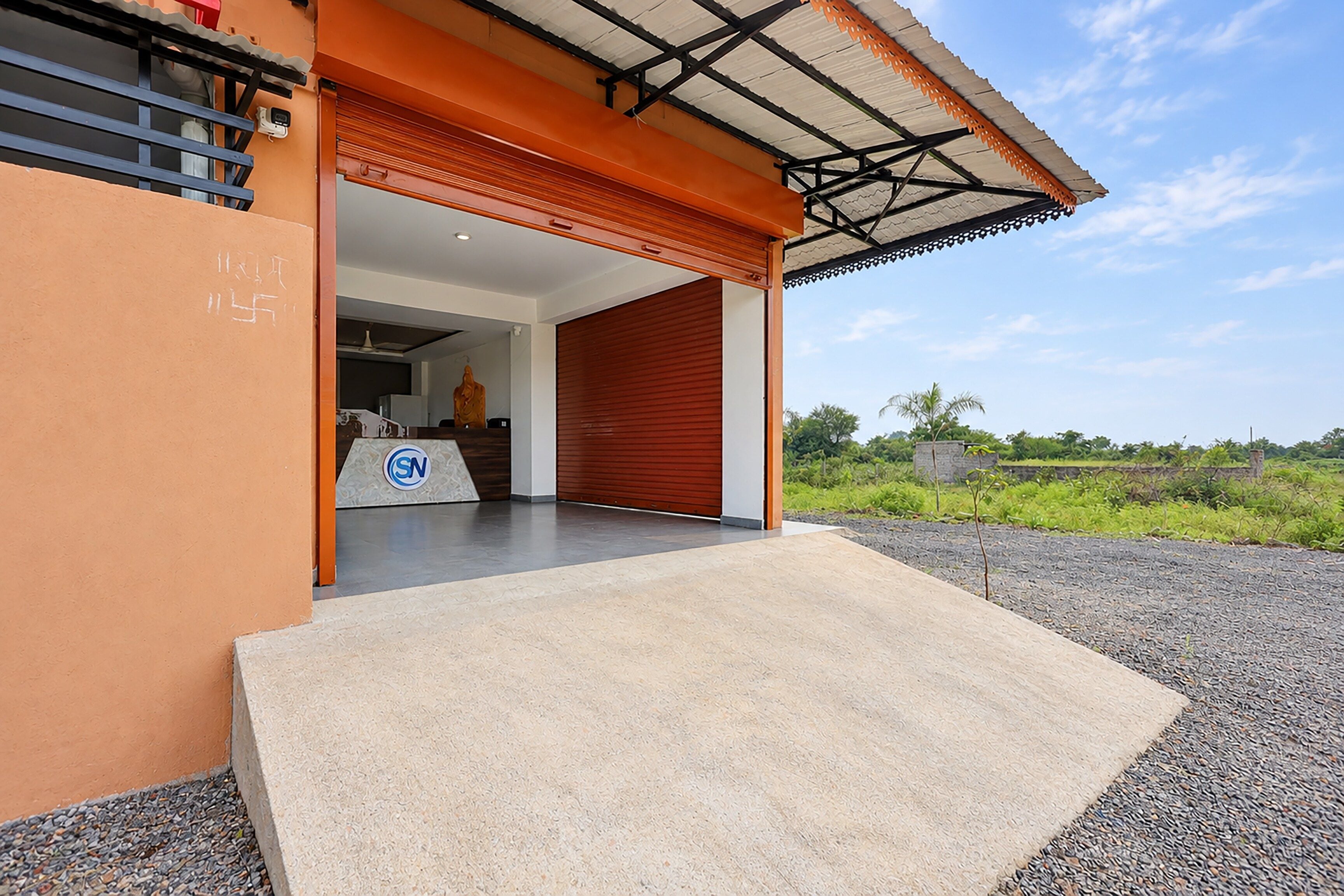 Un edificio moderno con puerta de garaje, logotipo visible y zona de acceso pavimentada.