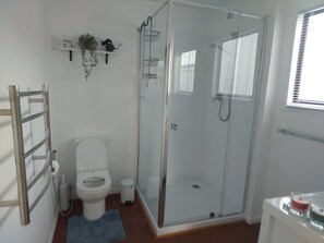 Un baño moderno con ducha de vidrio, inodoro y lavabo.