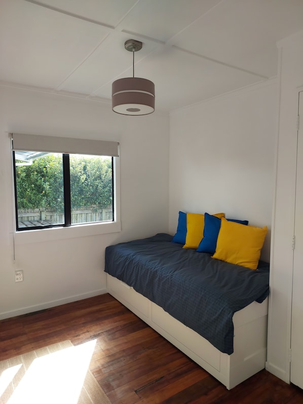 A bedroom with a bed, a window, and a ceiling light.