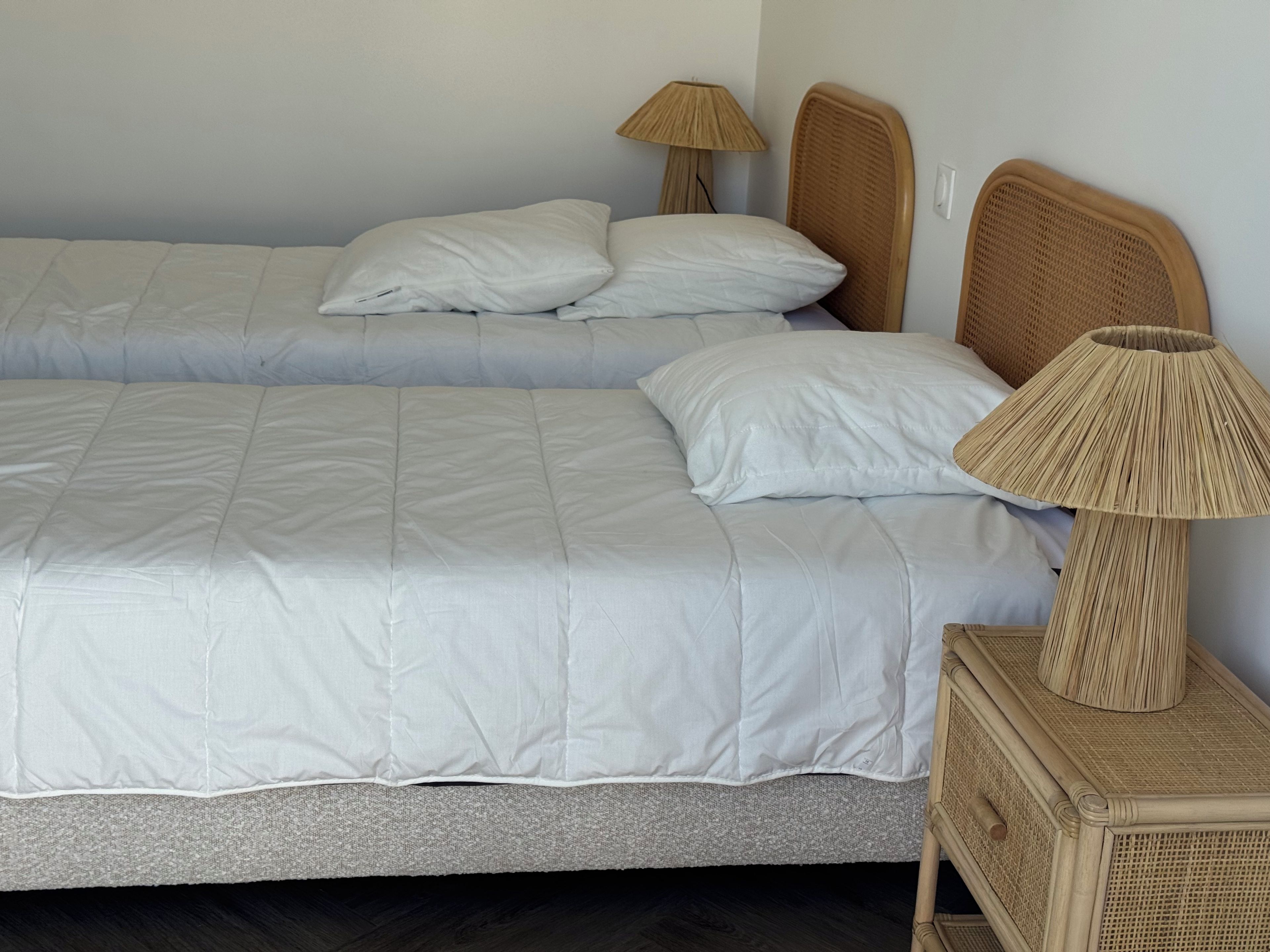 A double bed with white bedding and two bedside lamps.