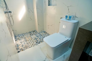 Un bagno con doccia, WC e piastrelle decorative.