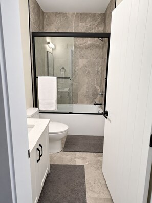 Full bathroom with a bathtub/shower, towels and a hair dryer. - Ladner suite, kitchen, A/C and laundry (Delta)