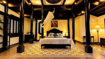 A traditional room with a bed, a hanging light fixture, and a patterned floor.