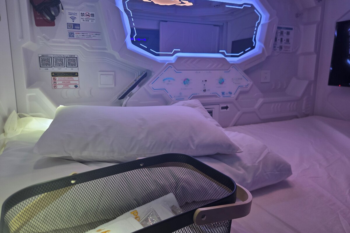 Una habitación futurista con una cama, un panel de control y un monitor.