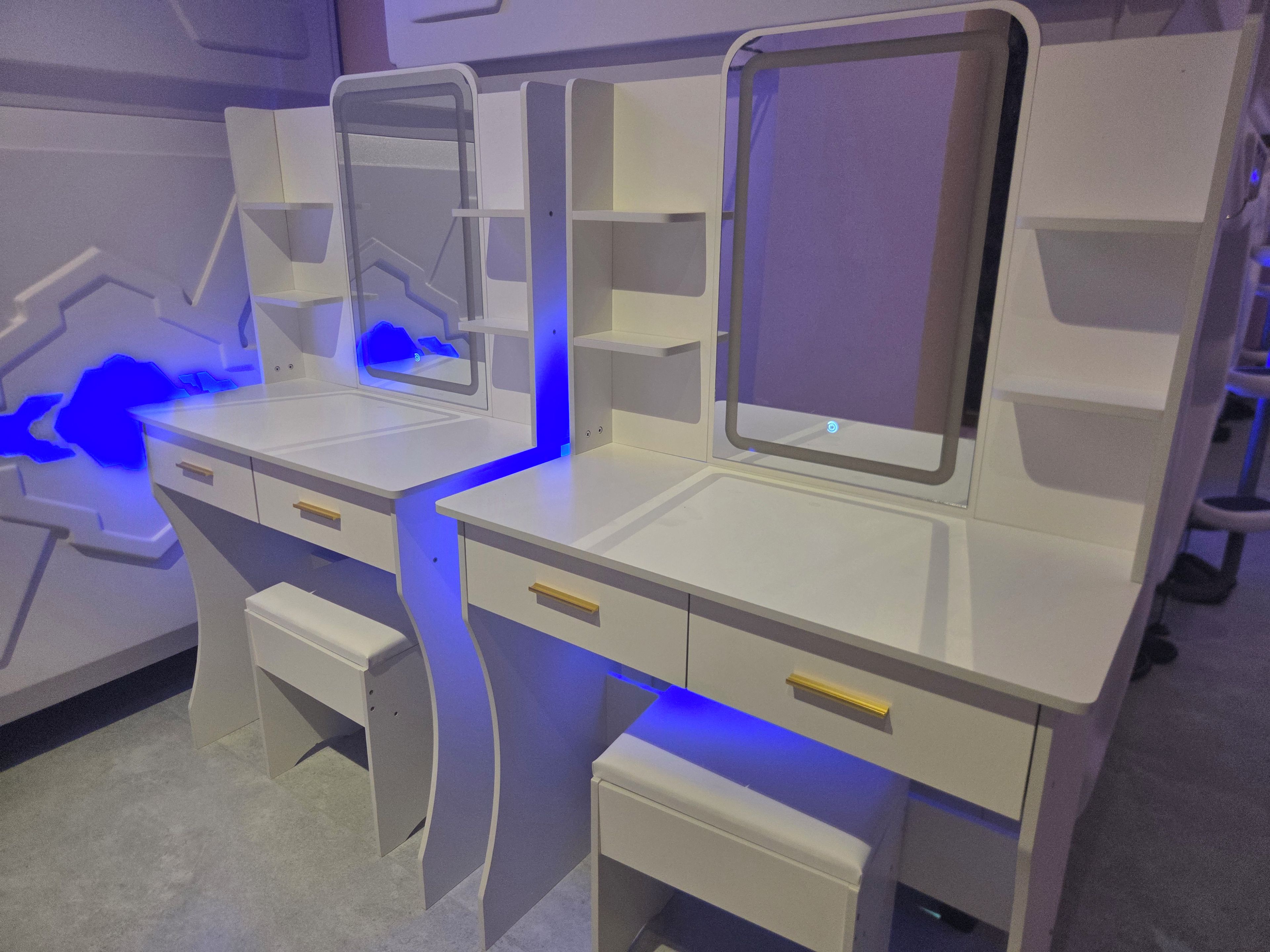A modern, white desk with a built-in monitor and storage compartments.