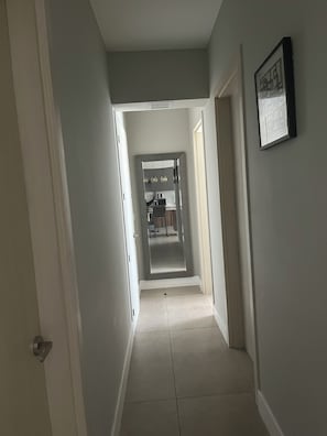 A hallway leading to a kitchen area with a tiled floor and a framed picture on the wall. - New Listing (Tijuana)