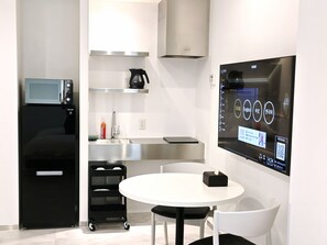 Eine moderne Küche mit integriertem Mikrowellenherd, einer Kaffeemaschine und einer digitalen Anzeige an der Wand.