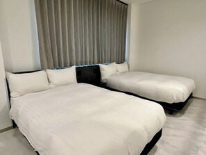 A hotel room with two beds, a large window with curtains, and a plain white wall. - New Listing (Toshimaku,minamiootsuka)