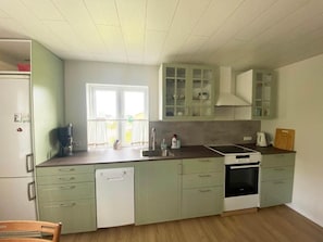 Une cuisine équipée d’un lave-vaisselle, d’une cuisinière et de placards.