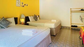 A hotel room with two beds, a wooden ceiling, and patterned floor tiles.