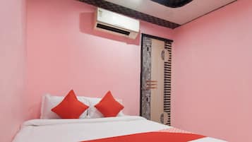 Una habitación con una cama, una puerta con un diseño decorativo y un equipo de aire acondicionado en la pared.