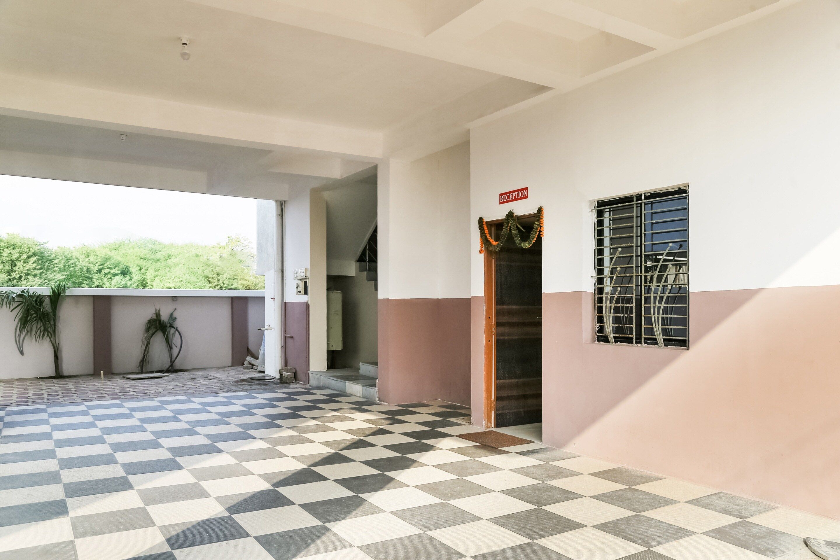 A building with a checkered floor, a reception area, and a window with a metal grill.