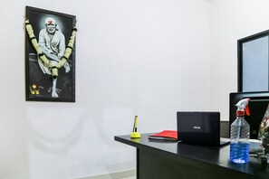 Un escritorio con una computadora portátil, una botella de agua, una carpeta roja y un bolígrafo.