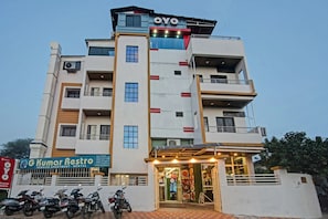 A multi-story building with a restaurant entrance, several balconies, and parked motorcycles. - Hotel O Gkumar Restro (Nagpur)