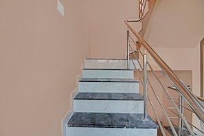 Una escalera con escalones de mármol y barandillas de metal.