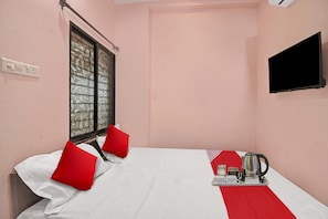 A hotel room with a bed, a window with a view, a flat-screen TV, and a tray with a kettle and cups. - Hotel O R K Guest House (Nagpur)