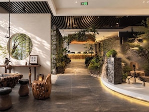 A modern interior with a central pathway, wooden furniture, and indoor plants. - Jianshan Song-Style Aesthetic Hotel (Kunming)