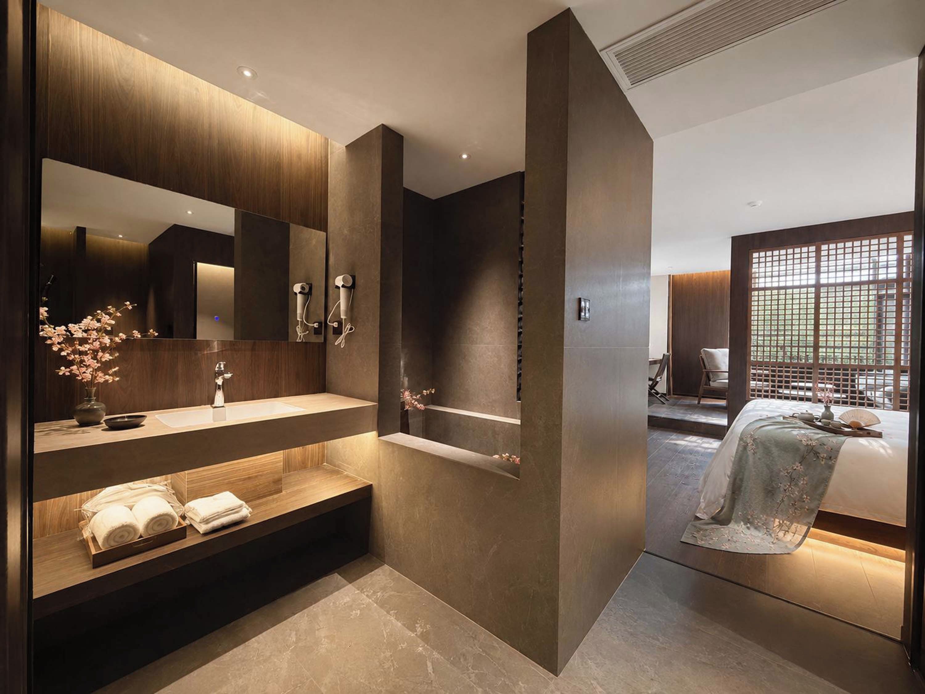 Un baño moderno con un espejo grande, una bañera y un tocador con toallas.