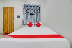 A room with a bed, a wooden door, and a curtain. - Hotel O by OYO Roman Inn (Nagpur)