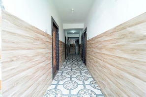 Un pasillo con baldosas de diseño y paneles de madera.