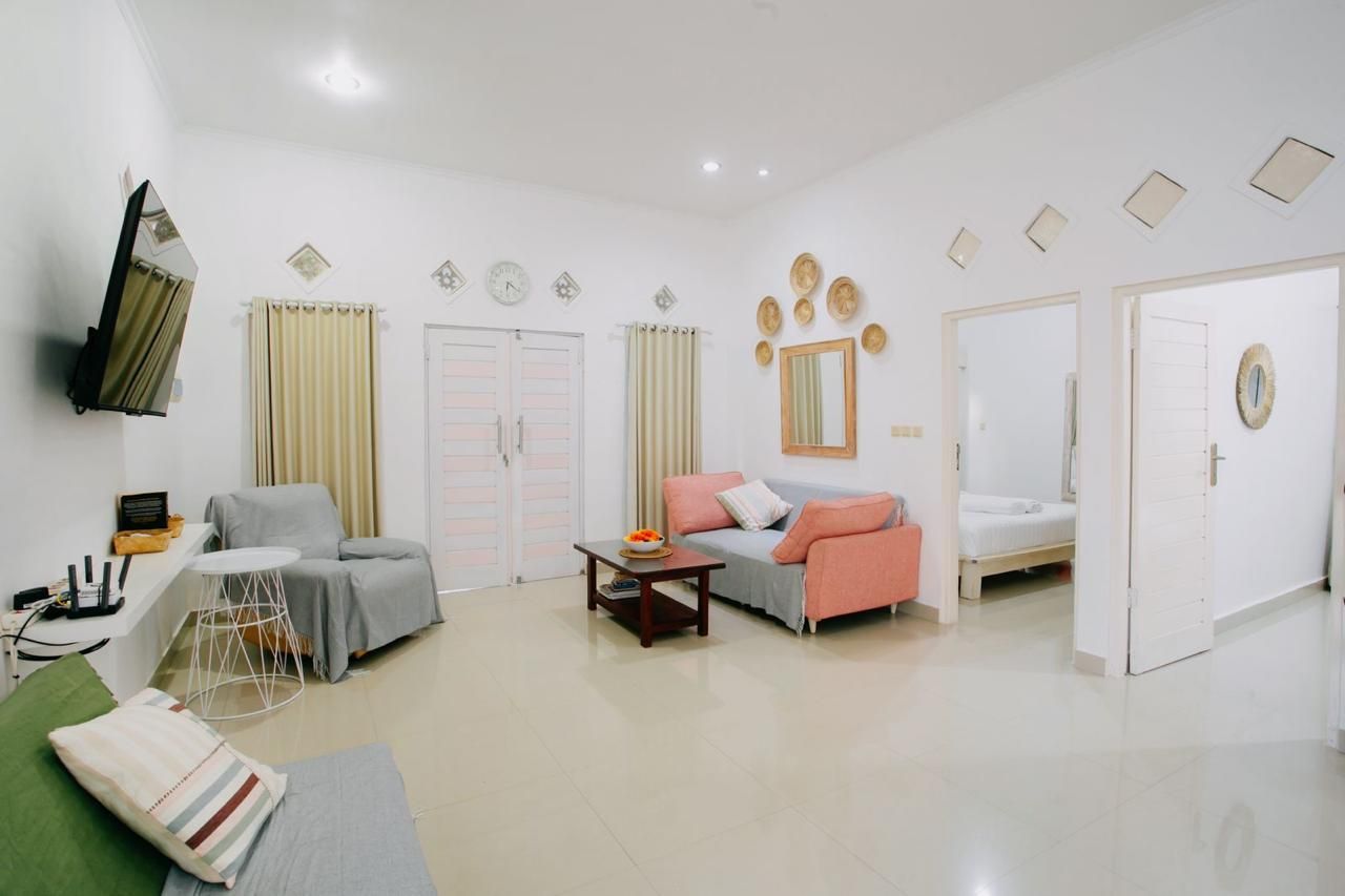 Una sala de estar moderna con un sofá, una mesa de centro y un televisor montado en la pared.