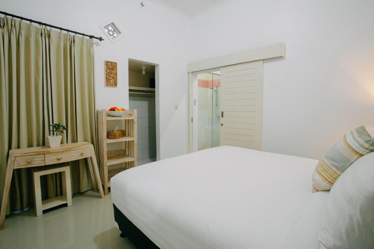 Un dormitorio con cama, escritorio, armario y estante con objetos.