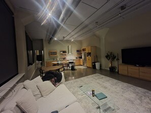 A modern living room with a large flat-screen TV, a sofa, and a coffee table. - Waterfront location for rent with great quick escape! (North Tonawanda)