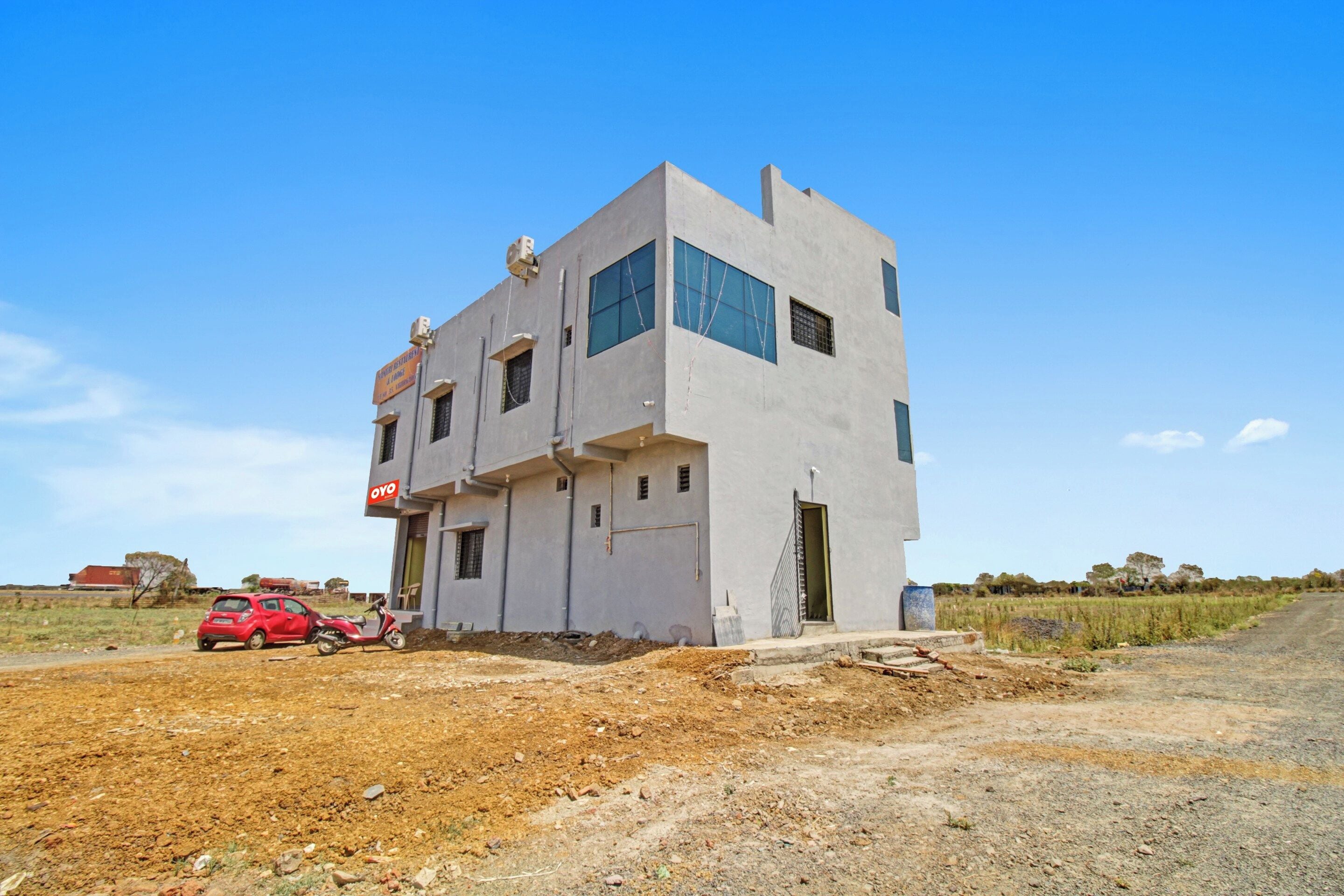 A modern two-story building with a flat roof and large windows.