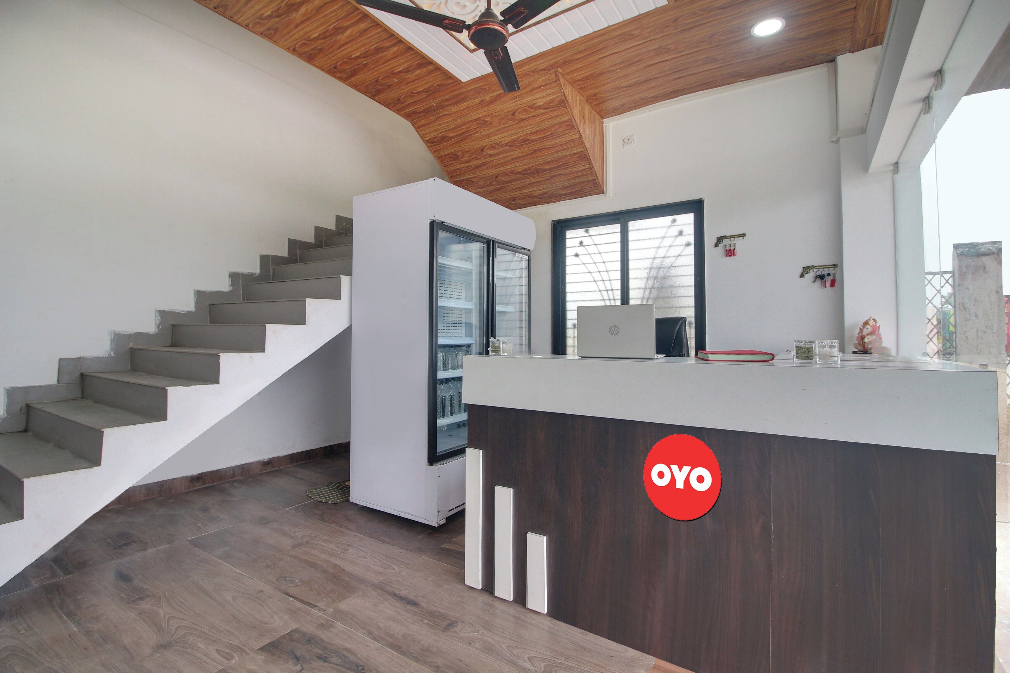 A modern interior with a staircase, a reception desk, and a ceiling fan.