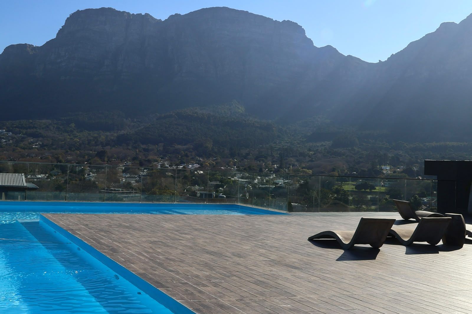 Ein Poolbereich mit Liegestühlen und Blick auf die Berge.
