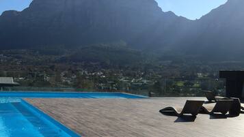 Ein Poolbereich mit Liegestühlen und Blick auf die Berge.
