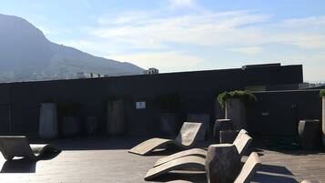 Eine Dachterrasse mit modernen Lounge-Möbeln und Topfpflanzen.