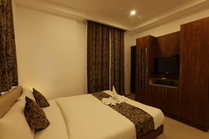 Habitació d'hotel amb llit, televisió i armari.