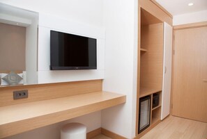 A modern bathroom with a built-in TV, wooden vanity, and a shower area. - Viona Otel (Izmir)
