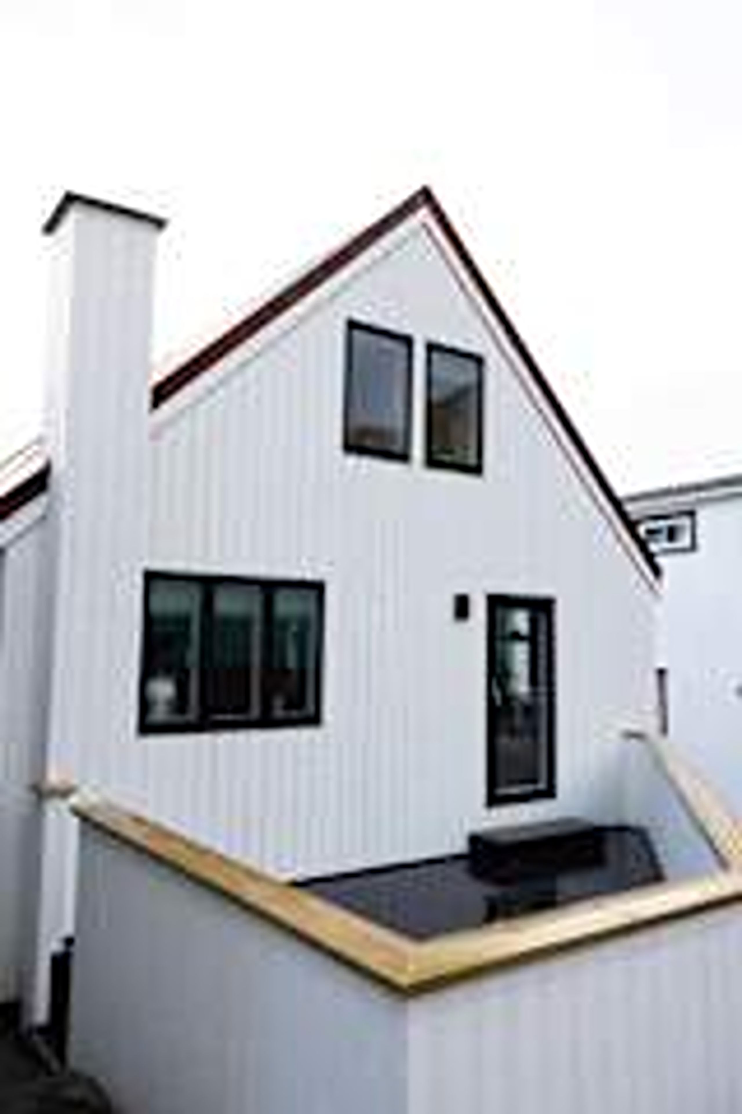 A modern two-story building with a flat roof and a small balcony.