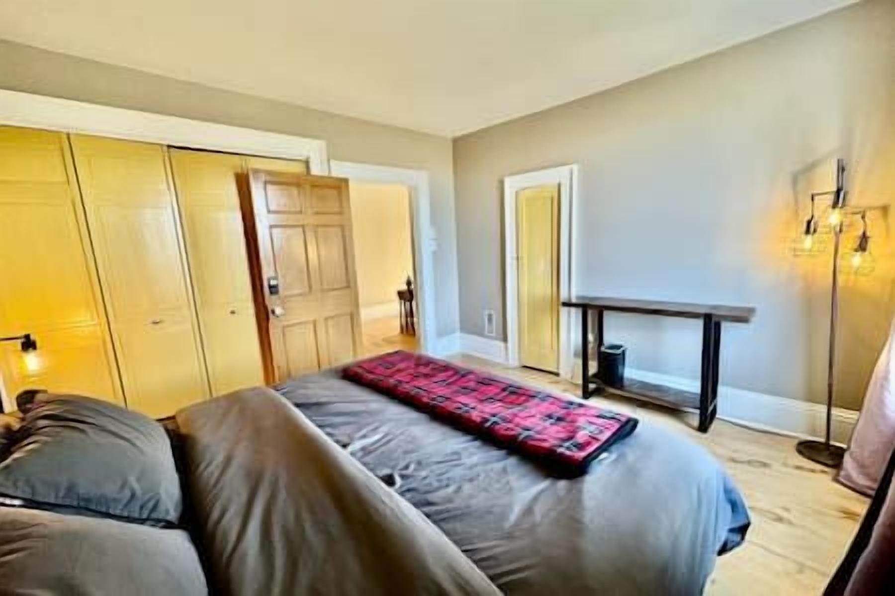Une chambre à coucher avec un lit, une table de chevet, une lampe et une armoire.