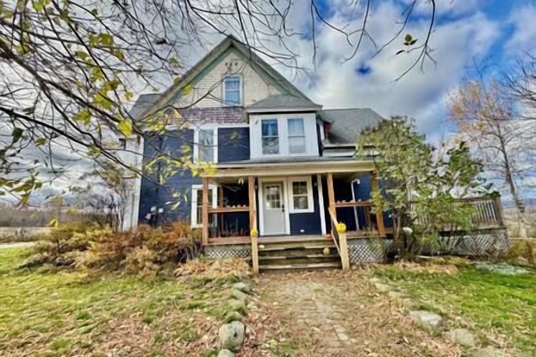 A two-story house with a front porch, a covered entryway, and a visible front yard.