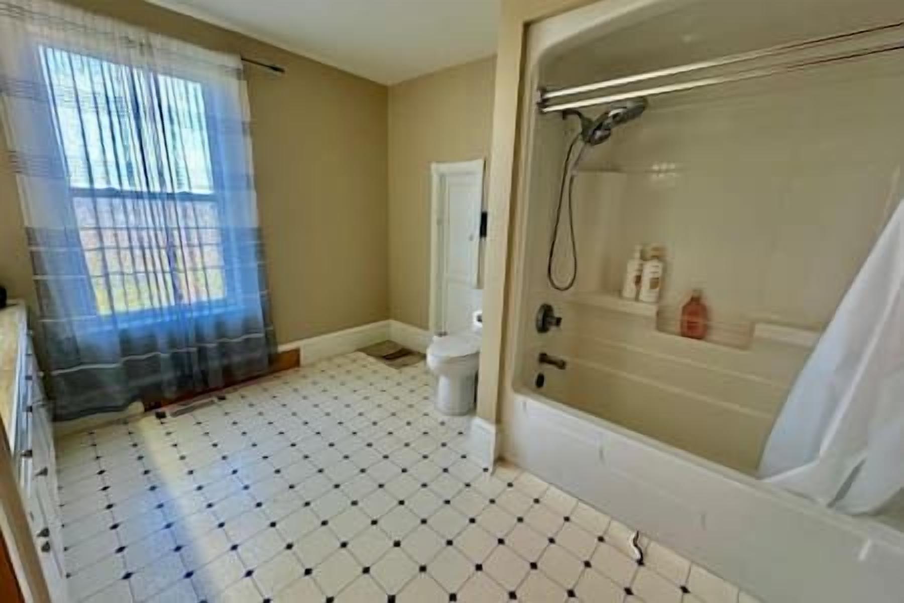 A bathroom with a bathtub, toilet, and shower.