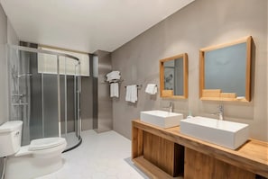 A modern bathroom with a glass-enclosed shower, a white toilet, and a wooden vanity with two sinks. - Wuyuan Jianwai Rill Wild Homestay (Shangrao)
