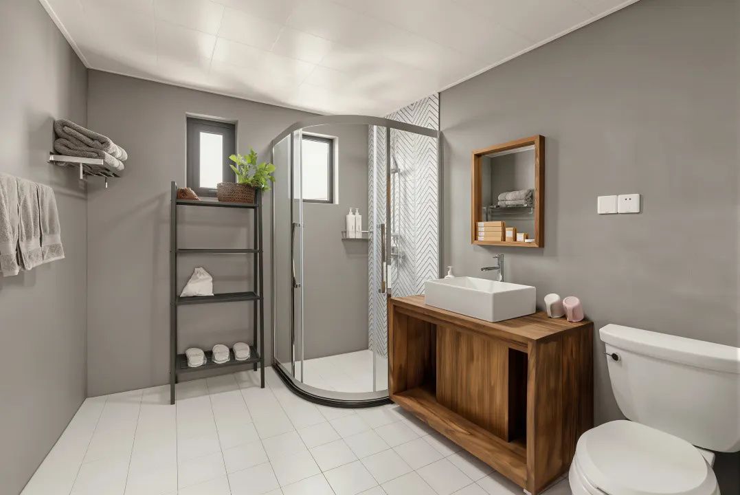 Un baño moderno con cabina de ducha de vidrio, tocador de madera y un inodoro blanco.