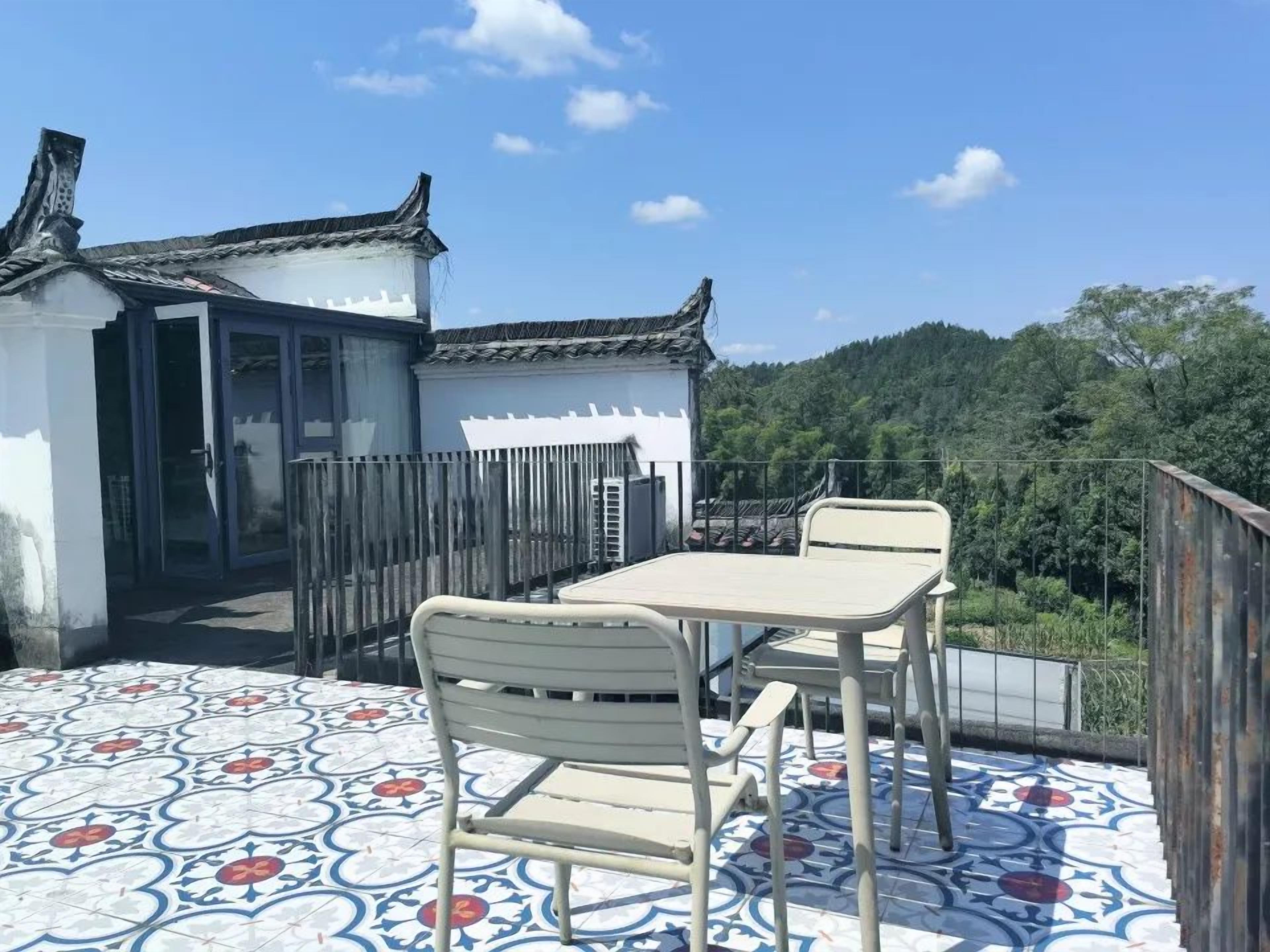A traditional building with a tiled patio, a table, and a chair.