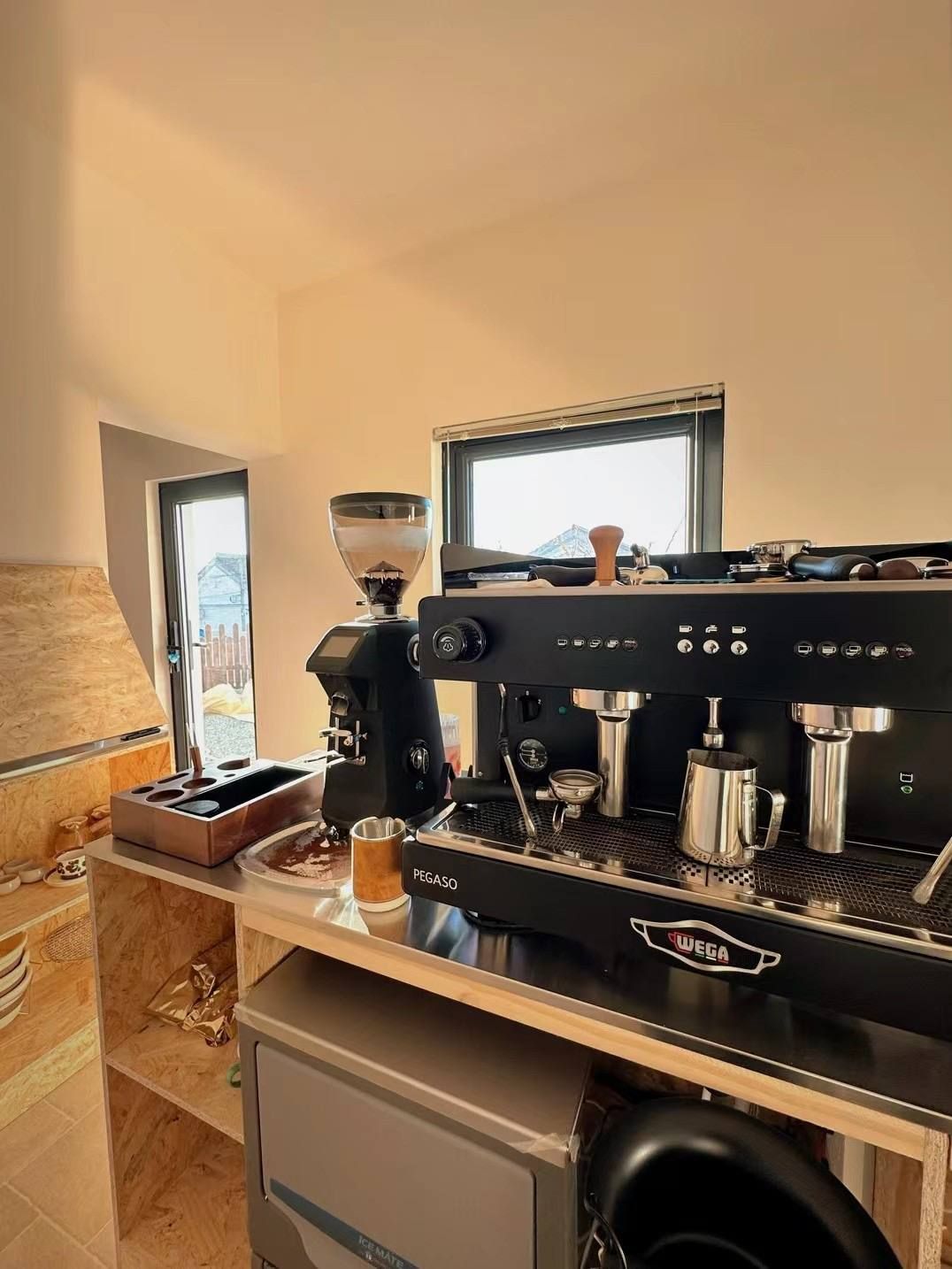 Et moderne køkken med kaffemaskine, et vindue og udsigt til en bygning.