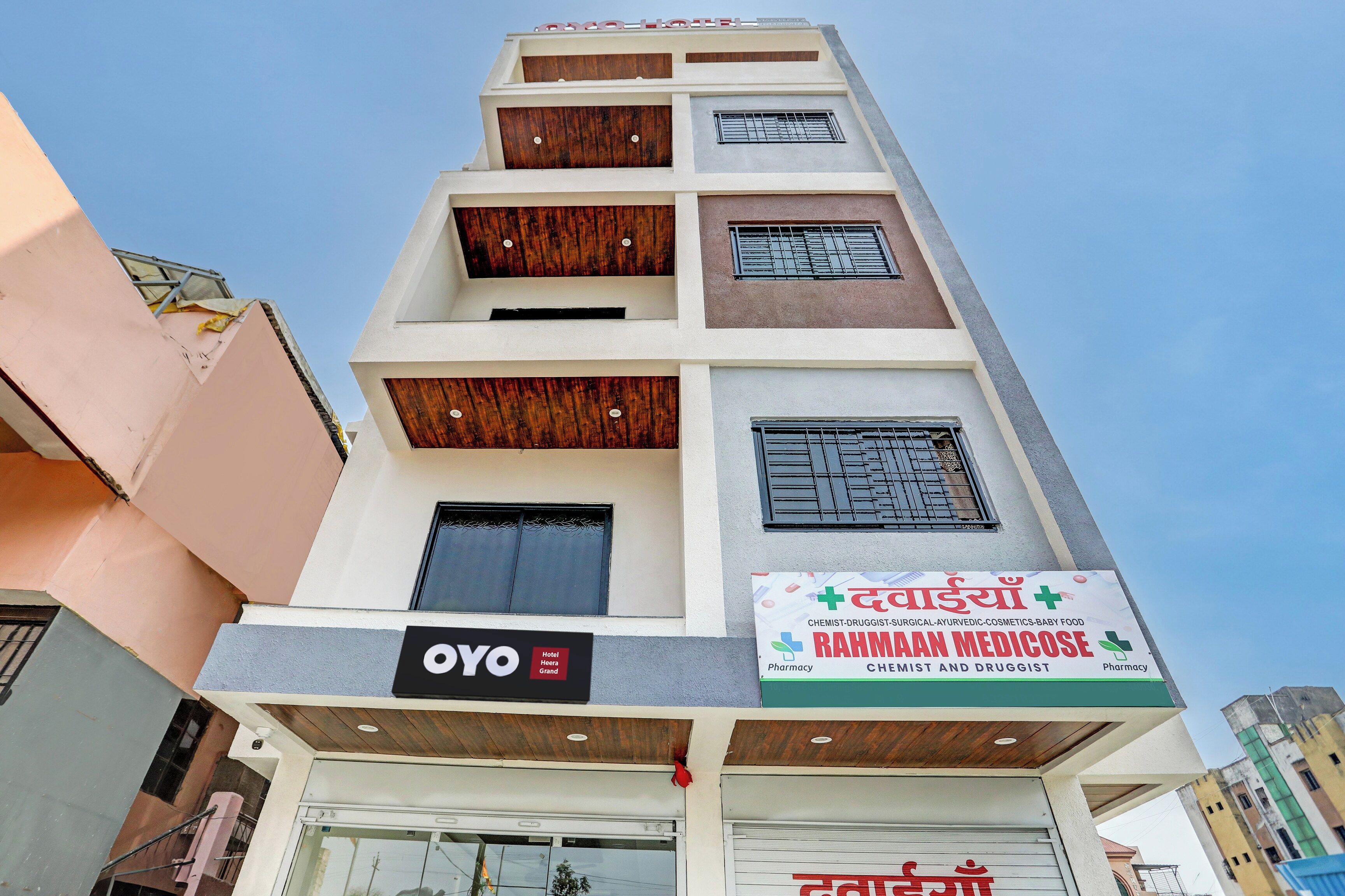 Un edificio a più piani con un cartello che indica 'OYO Hotel' e la farmacia 'Rahmaan Medicose' al piano terra.